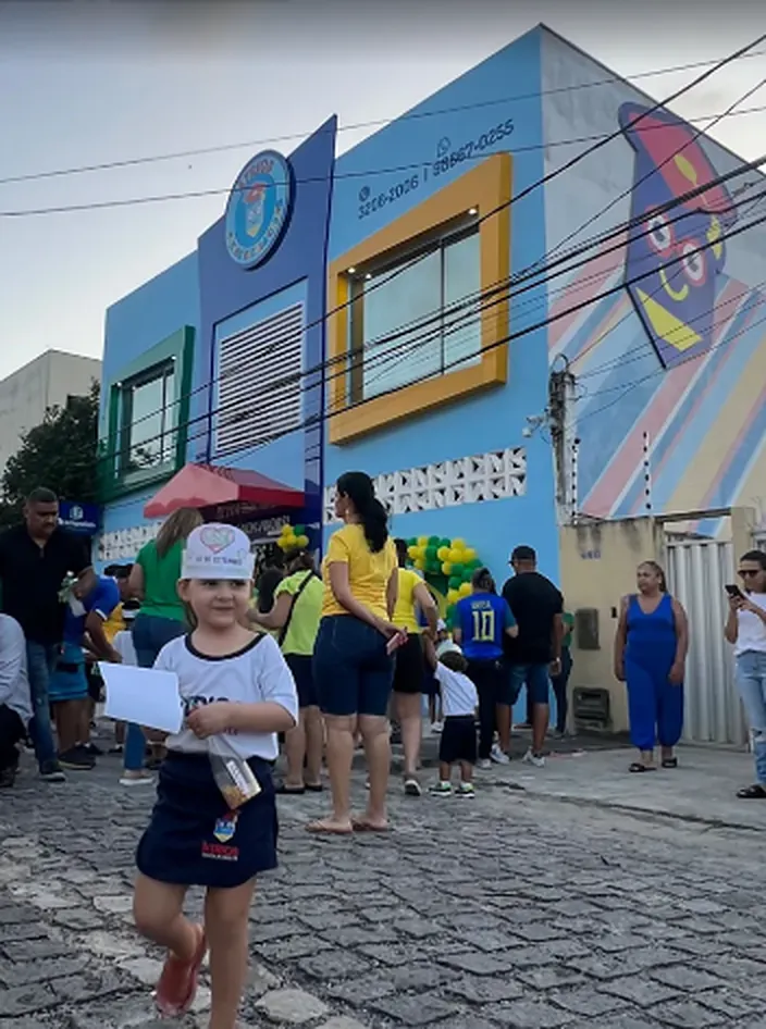 Crianças e famílias na porta da escola no dia do desfile